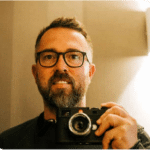Portrait von Sascha Hoecker mit Kamera