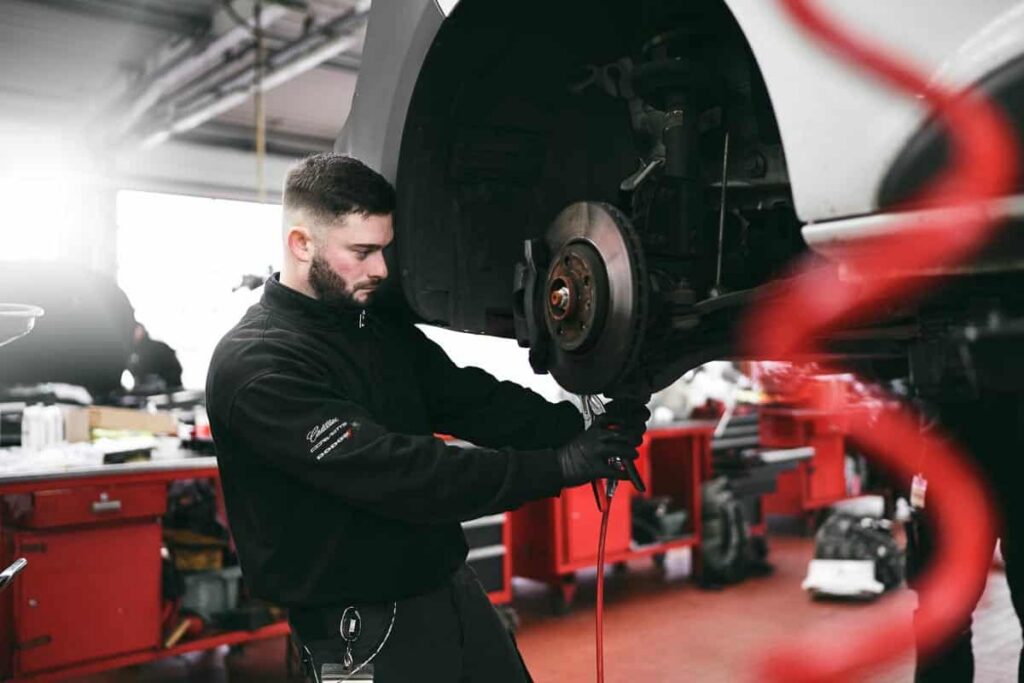 Mitarbeiter bei der Arbeit an einem Fahrzeug in einer Werkstatt