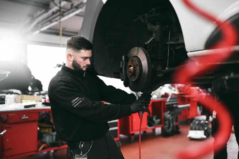 Bild zeigt Mechaniker beim Schrauben in einer Werkstatt