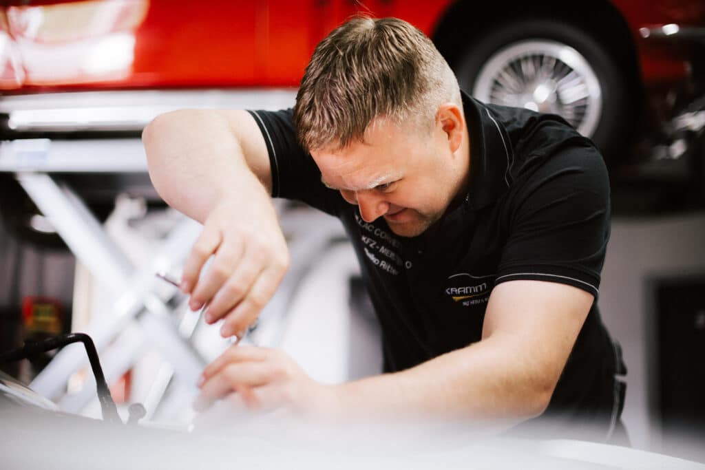 Employer Branding Mitarbeiter eines Berliner Autohauses bei Reparatur an einem Fahrzeug