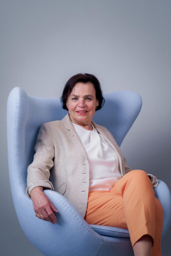 Bild zeigt ein offenes freundliches Portrait einer Mitarbeiterin einer Berliner Agentur sitzend