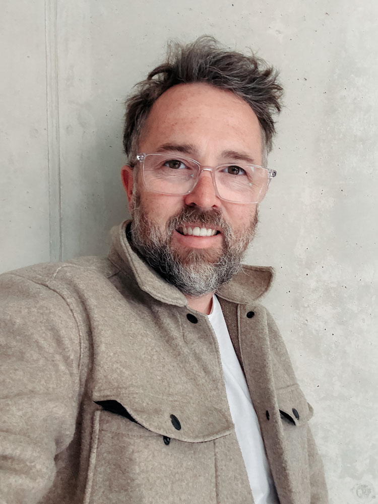 Fotograf Sascha Hoecker in seinem Studio vor einer Sichtbetonwand